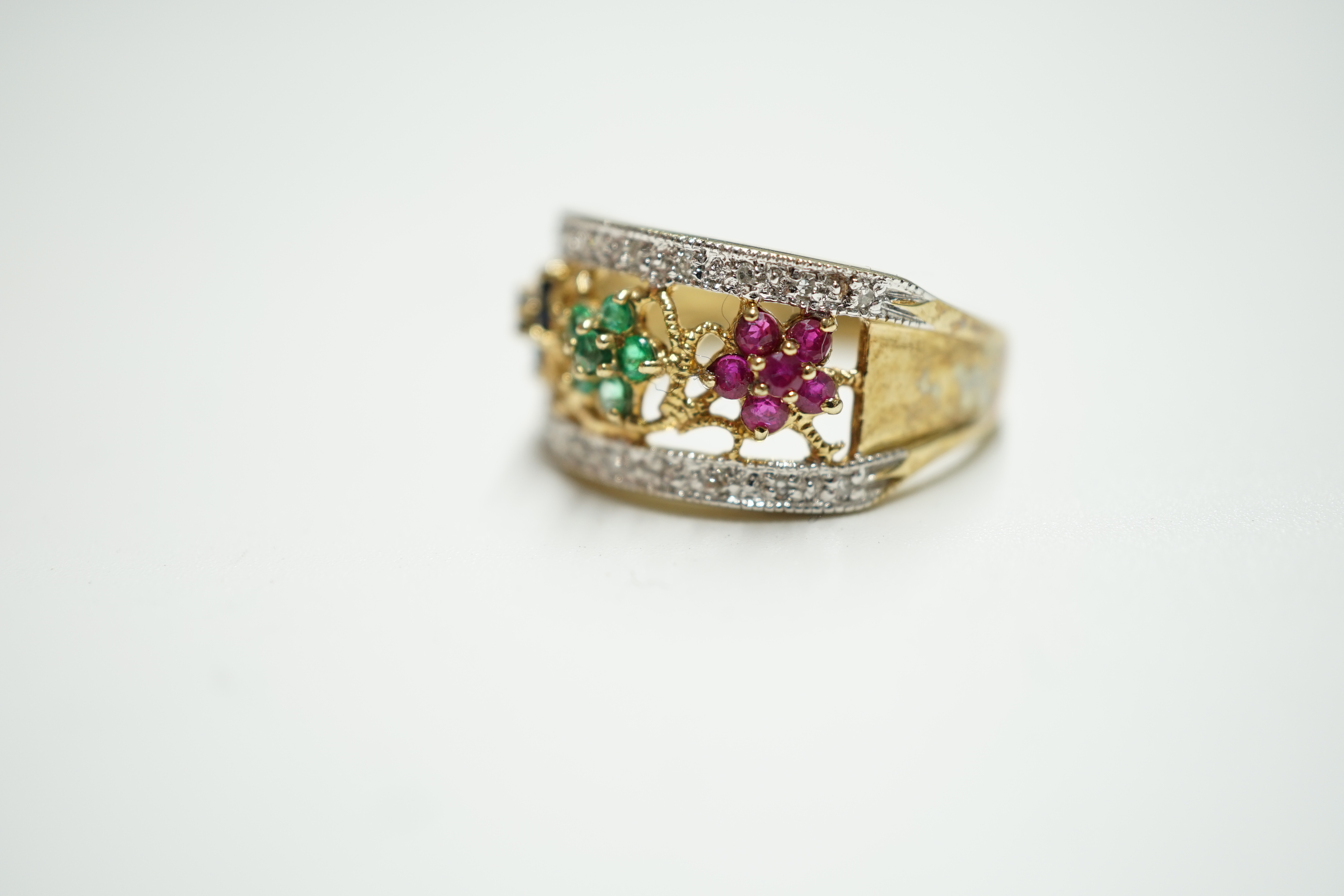 A modern 9ct gold, emerald, ruby, sapphire and diamond set triple flower head cluster ring, size P, gross weight 3.9 grams. Condition - fair to good